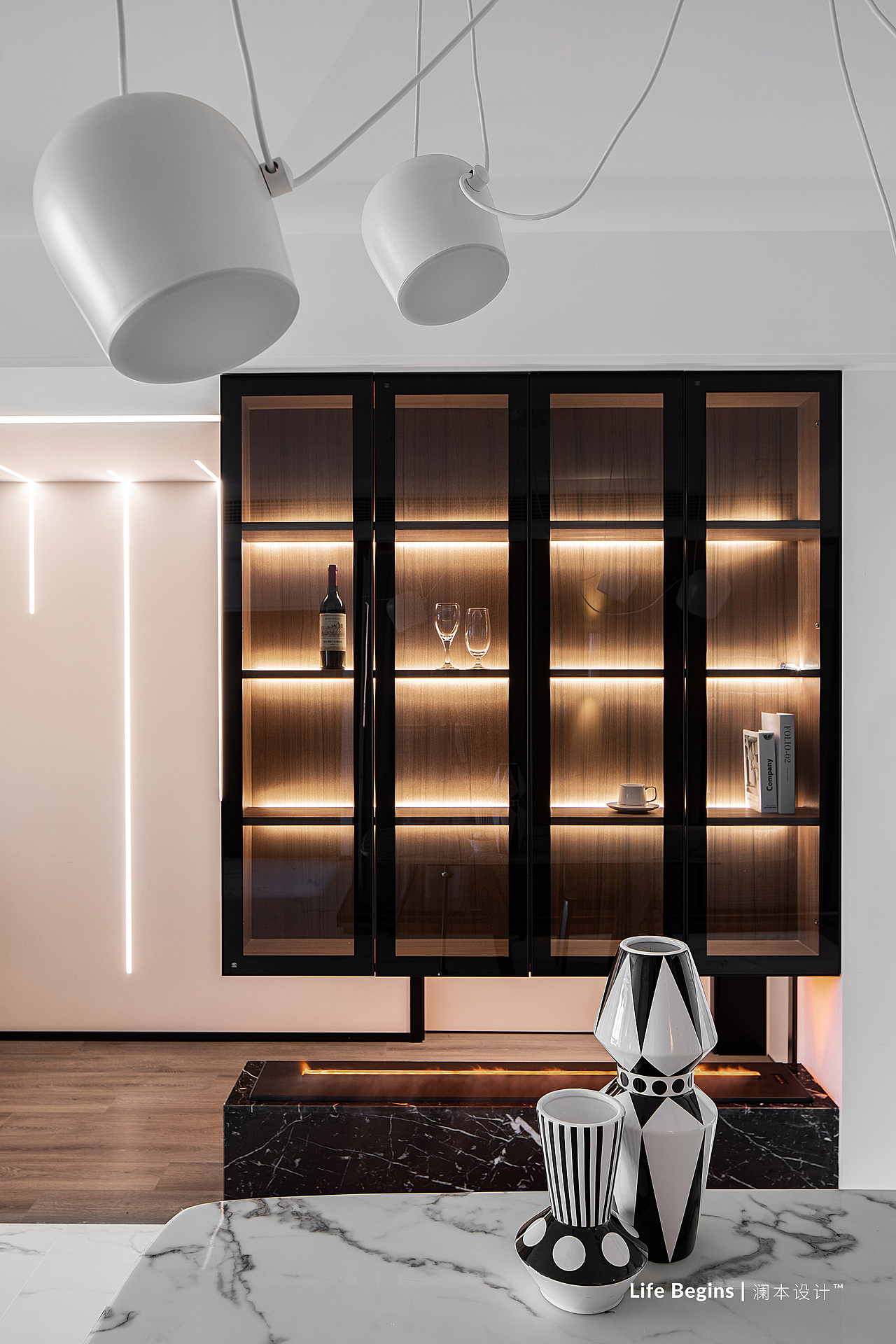 一旁的餐厅背景设计为黑框玻璃展示柜,其上部从顶面往下生长,  br>起