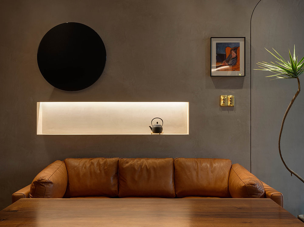 入门左侧巨大的黑色柜式展示和右边金属立杆垂挂式展示形成视觉上的轻重对比,空间的布局以休息沙发组和品酒区为中心,弧形的底墙展柜让整个空间有了一种包围的感受。
产品展示在方式上进行区分,不同展示方式一方面是强化产品单属性优势,另一方面是让展示方式更能融进整体的空间氛围里。