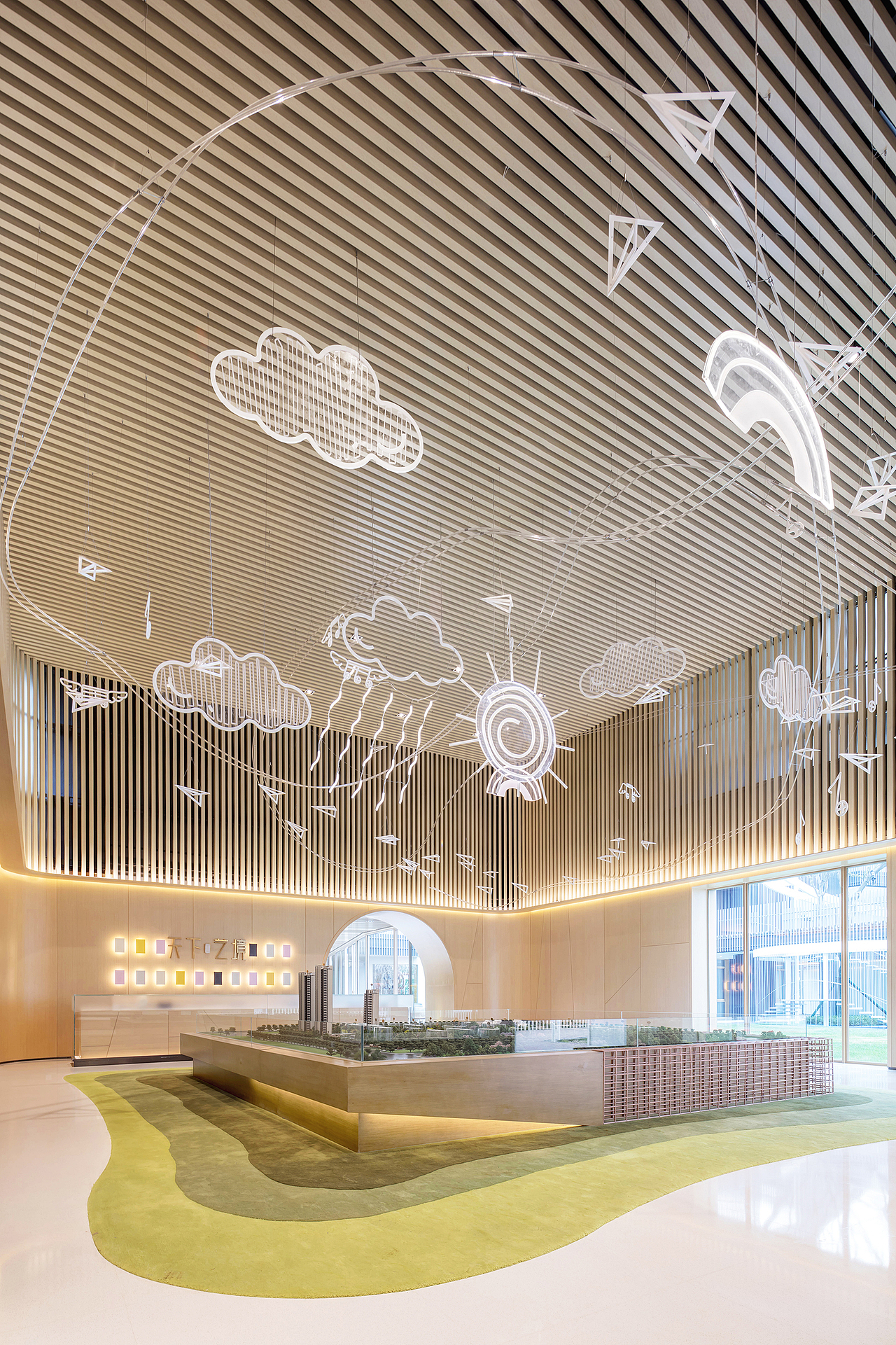 整个空间墙面以木饰面处理,作为视觉焦点——沙盘,我们一方面要通过独特的天花吊灯设计,引来访者关注,又不能让太过强烈的设计抢夺空间本身的功能需求。沙盘特意选用了深色木和草绿地毯,上浅下深的设定,既平衡了天花的图案,也契合整个空间的主题和功能。