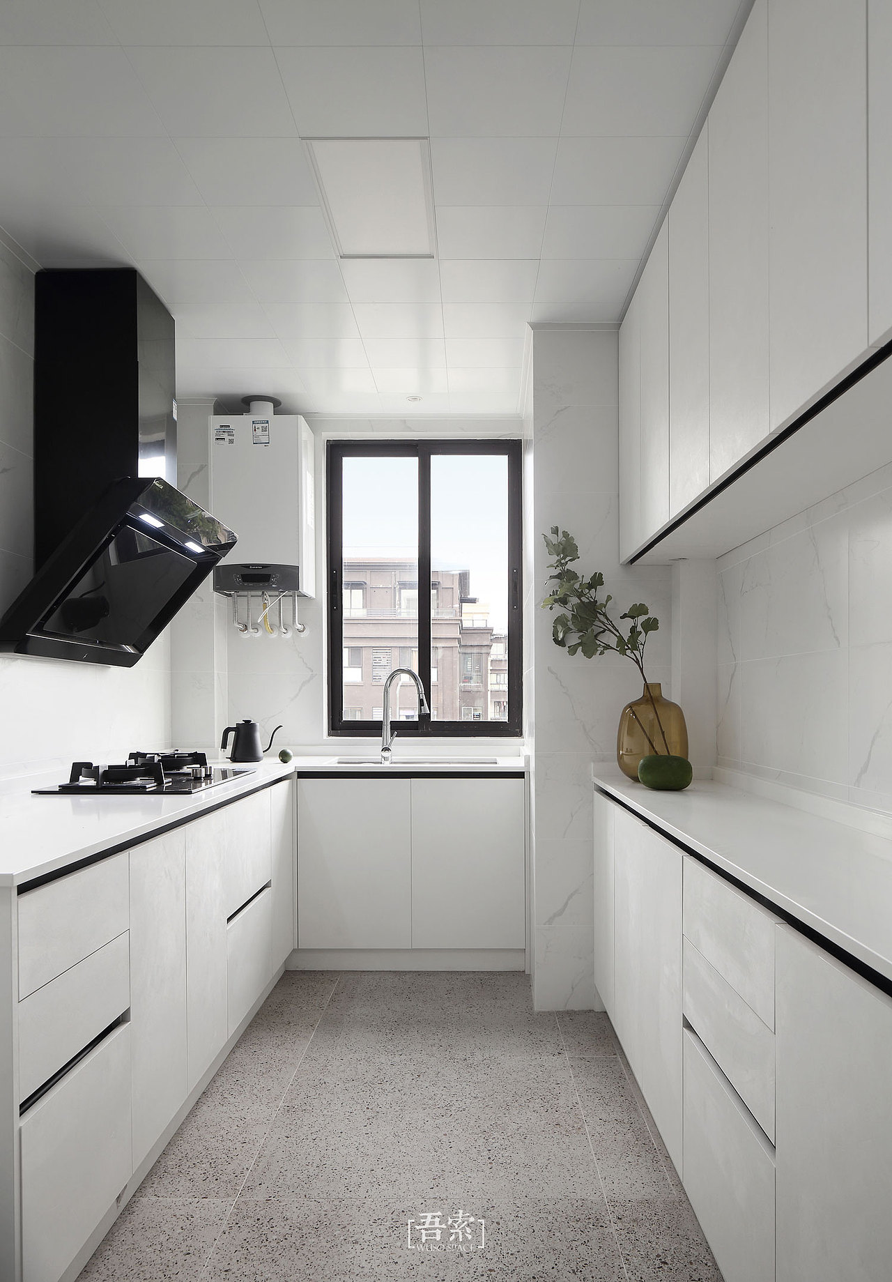 厨房也使用了纯粹的白色,结合地面的水磨石地砖,在自然的光影与机理当中感受生活的烟火味道。