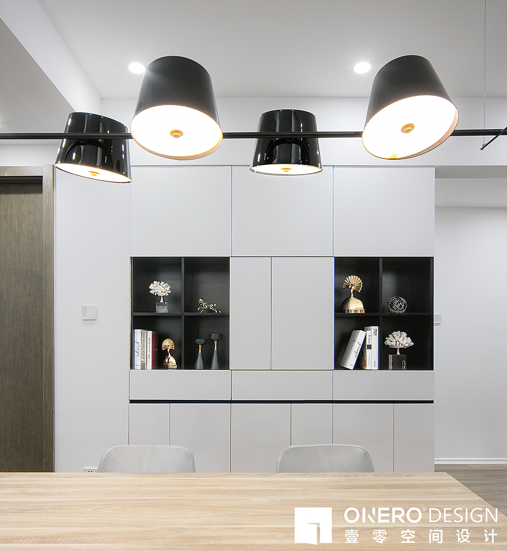 工作台背后整面墙的收纳柜,
除了放书籍、文件,更避免卫生间门直通入户门的尴尬,<br>柜门抽屉无拉手设计更具整体性。<br>