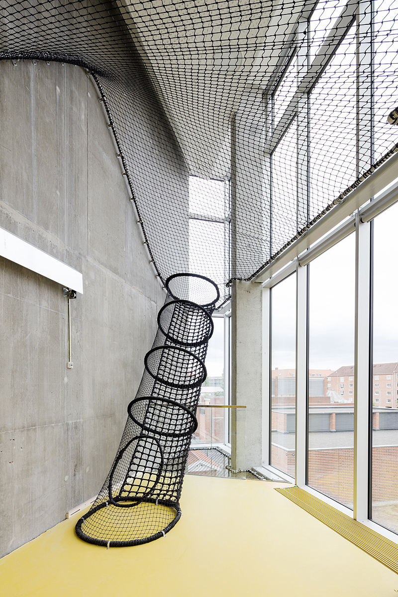 穿越建筑的路径注重发展和鼓励不同形式的流动。从二楼到三楼,“迷宫”迫使人们手脚并用攀爬穿越一组三维立方体;
他们也可以选择走一个竖向迷宫“捕鼠夹”。一张大网贯穿几层楼,用户在层与层之间可以爬上爬下——悬于空中;<br>滑梯和消防钢管提供了一种快速下楼的途径。