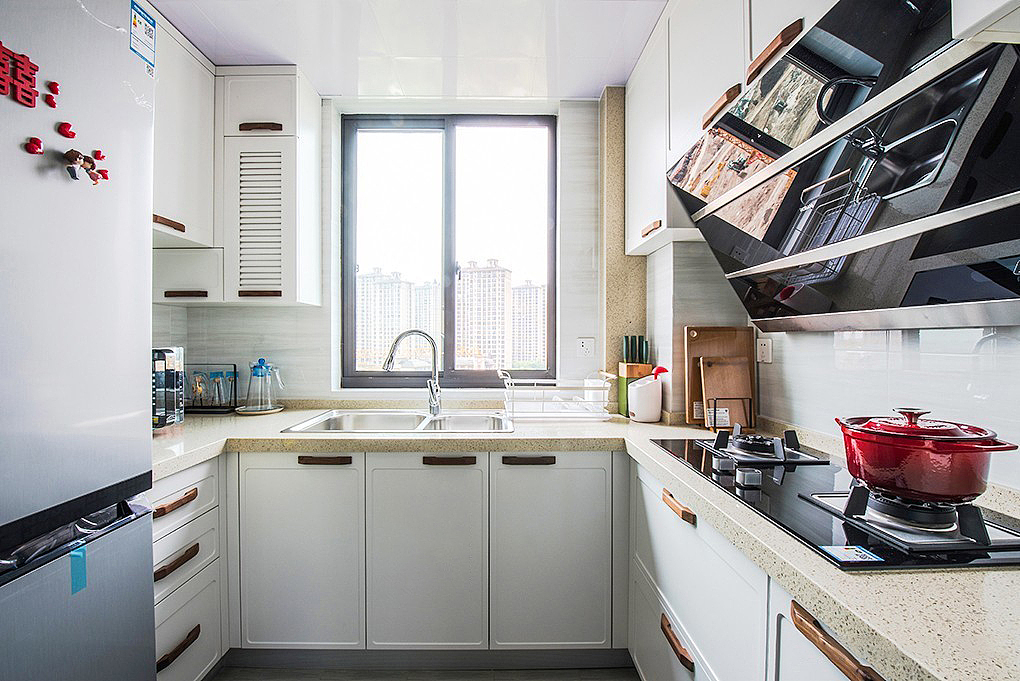 厨房讲究干净整洁
白色柜体+米色大理石台面<br>原木色手柄镶嵌其间<br>操作方便又实用