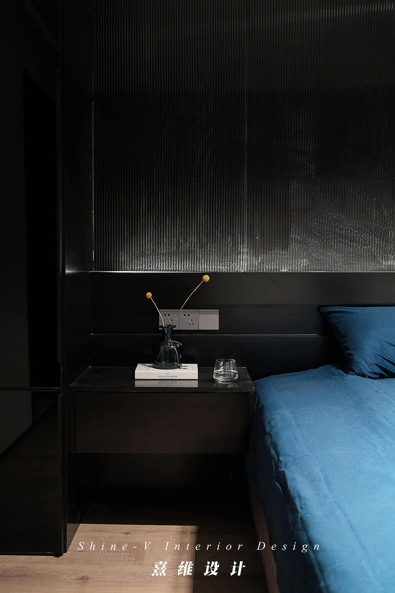 床头背景为通体黑色,上半部分是黑色的哑光烤漆长虹玻璃,细密的条纹