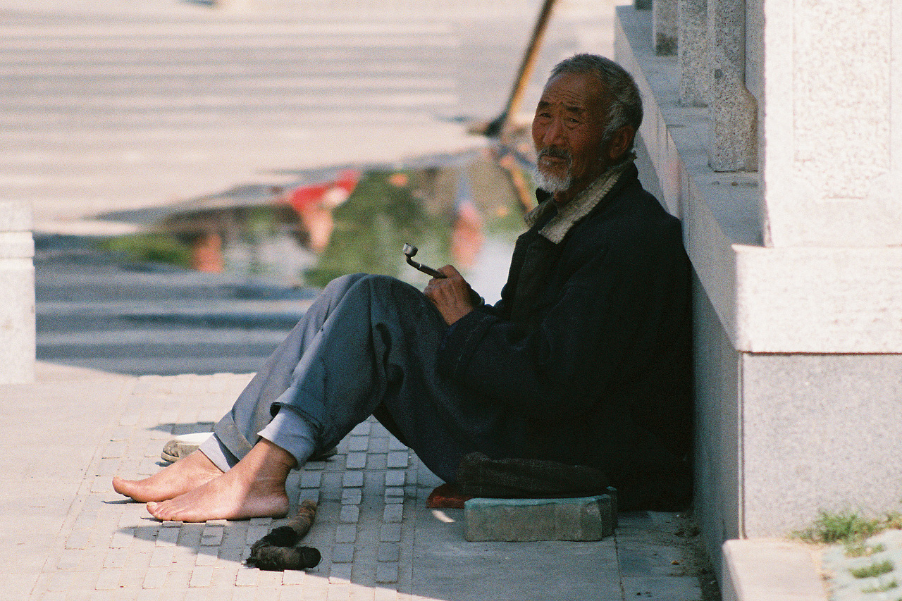 阴影下乞讨的老人
