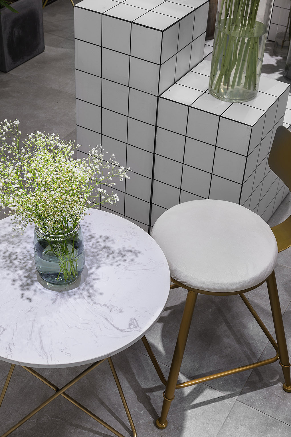 冷灰的地面，沁白的花台，让植物随性的散置在桌面，花架，地上；高高低低像极了这个阶段的“自己”，作品落地后的喜悦、设计之初的那个日日夜夜，这种理想与现实的反差，是累更是喜欢。