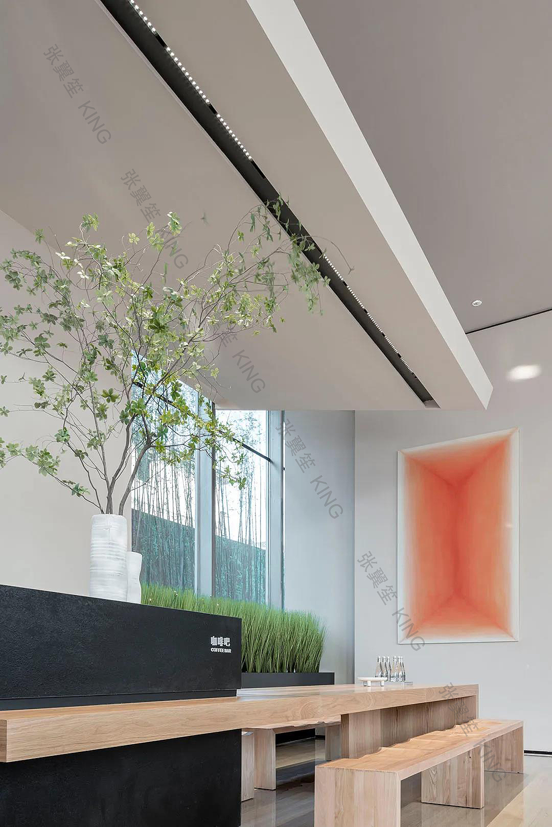 黑色石材吧台,肆意伸展的绿植,以及墙面的抽象画作组合,将水吧区衬托地更为精致。穿插于吧台的木质体块家具,延展了空间的功能。而背景那一簇簇翠绿,则呼应了空间的主题。