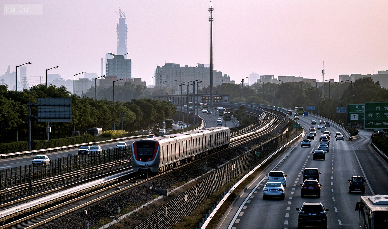 夕阳下的北京地铁八通线平行于京通快速在行驶