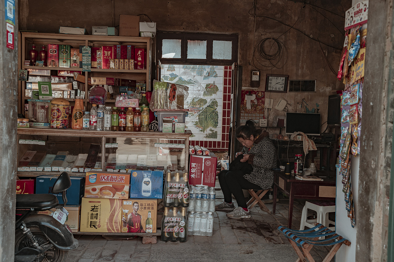 西街路南的小卖部,店主正专心地做针线活