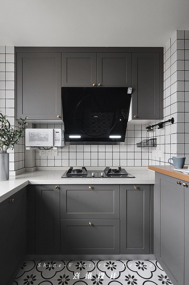 ▲为了使空间更为通透、宽敞，打掉了原户型的厨房墙体，定制的橱柜在颜色运用上搭配整体空间，开放式厨房在布局上和谐统一，延伸视觉感。
