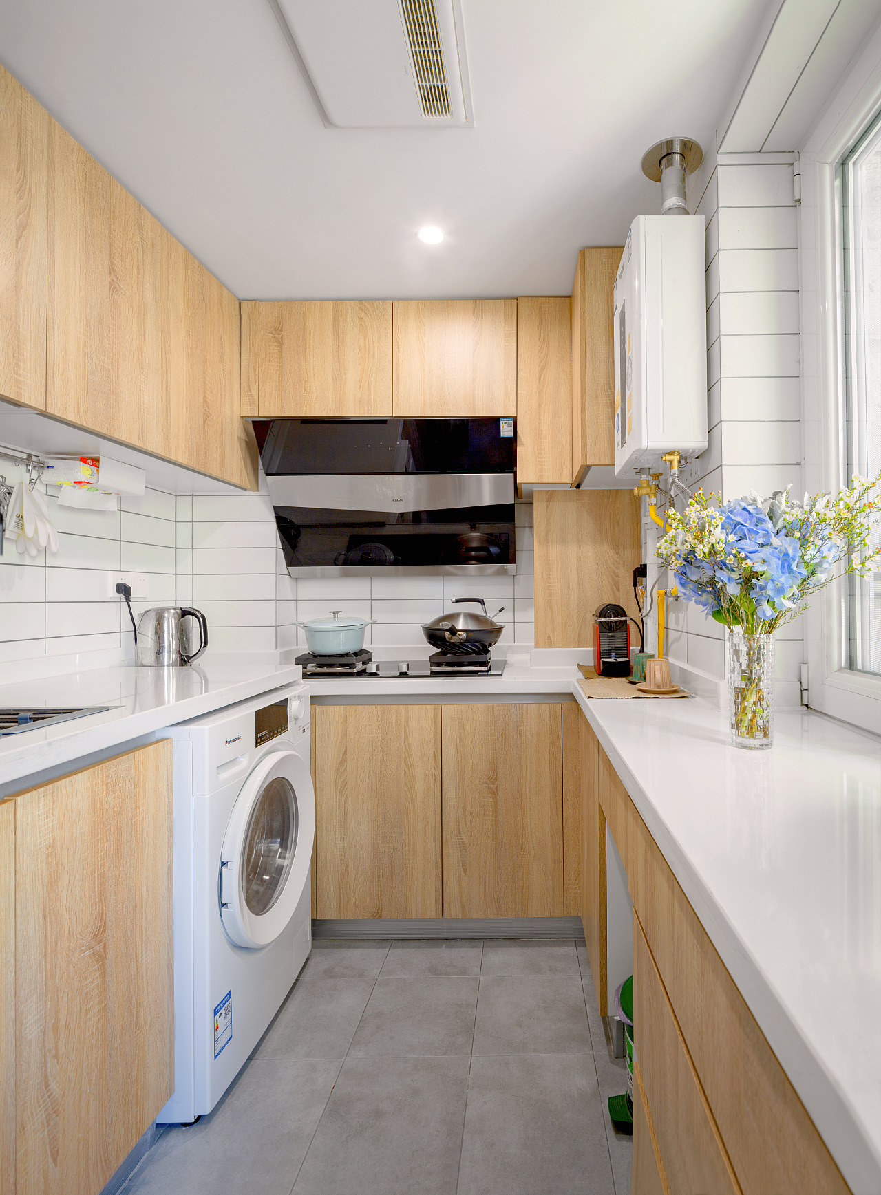 木色与白色的搭配干净又温暖,出于空间限制将洗衣机移至厨房,却很自然地融入其中。窗台上的花束,则为这个充满烟火气息的地方,带来不一样的色彩。
