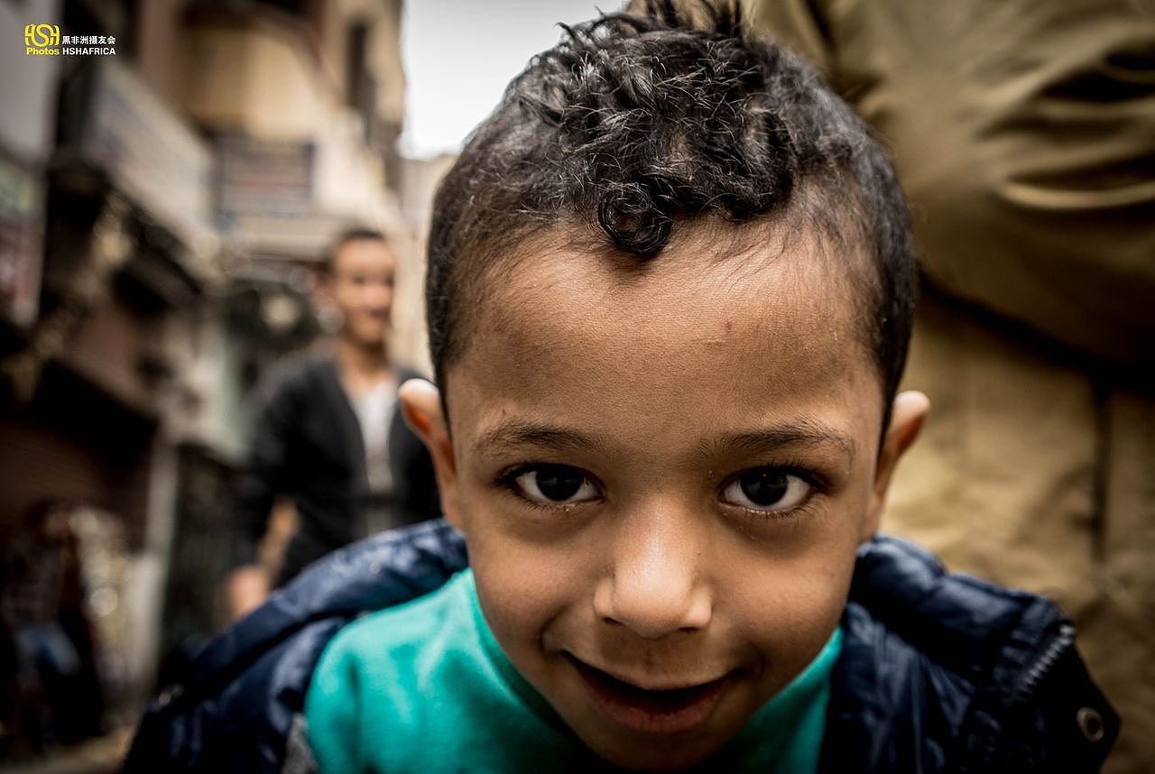 这个小孩跟着父亲来买油炸果，使劲让我镜头上凑。