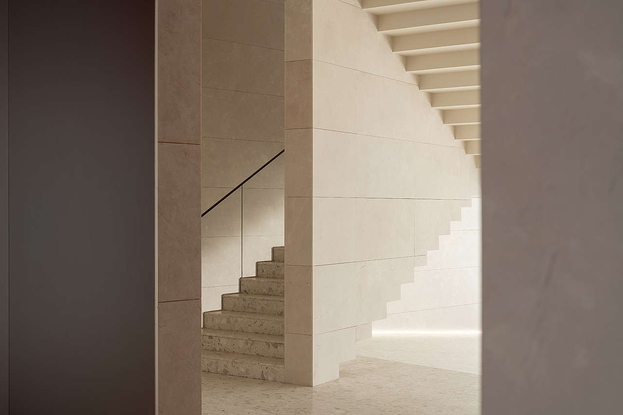 踏入建筑,入口由下挖式白色中庭建构起点,富节奏感的踏阶环绕在侧,对人们行经或逗留抱着从容姿态,无主从之分的开放性路径连接四方区域,择其一进入空间,这趟不是为了看一幅画,而是亲身浸入画中。