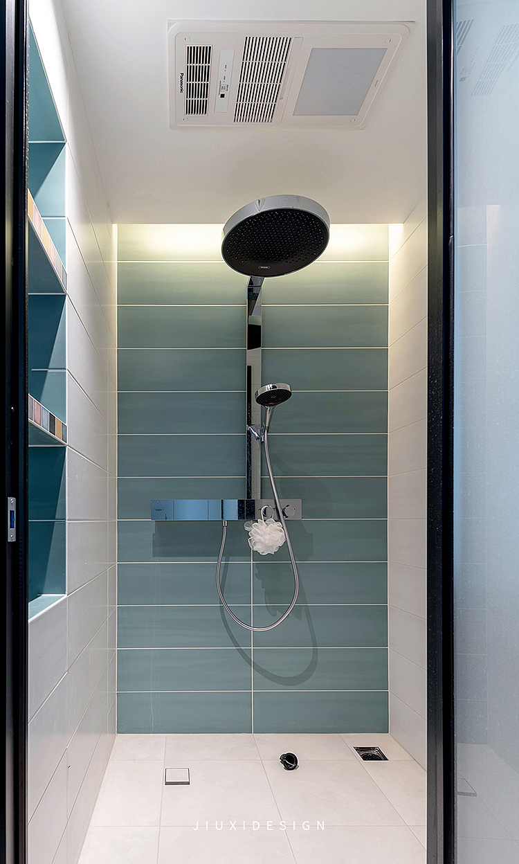 客卫的淋浴区设置了超大的花洒,塑造大流量的淋雨之感。
旁边设置了壁龛,用来存放洗浴用品,瓷砖在漫反射的灯带下格外清新。<br>