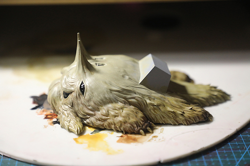 我先将整体涂成灰土黄色，然后在它四肢刷了多次棕色来进行过渡，最后再罩一层深棕渗线液，由于渗线液是油性的，所以只需刷一点就能渗透到模型的夹缝中形成好看丰富的色彩过渡，这时可用棉签轻轻擦一下油渍即可。