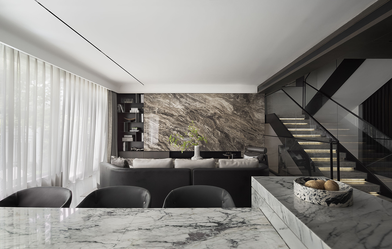 整体空间色彩以深浅不一的灰色系打造独特气质。客厅空间方正,天然大理石结晶出时间的浪漫,糅杂着金属线条。在深色木纹饰面板的相互结合下,各种材质以各司其职,引发了感官及精神层面对美的通感。