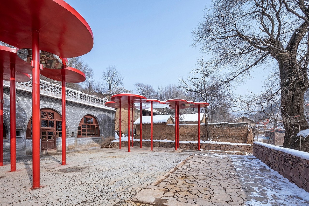 希望用一种新的、“似是而非”的设计语言,重现这一场景,这一原型。一组伞状的构筑物被设计出来,“伞帽”大小不一,彼此连接,形成由多个圆组成的不规则的“顶”,它覆盖了院落1/4的面积,并隐约成围绕大槐树的半环抱状。院落西侧倒塌厢房的位置,一个室外看台被构建起来,它呈梯形,东低西高,与老窑洞、大槐树,以及伞状构筑物一起,重新定义了场地的空间属性。室外看台一方面为室外剧场提供了观众的座位,另一方面也为俯视村落提供了一个高点。