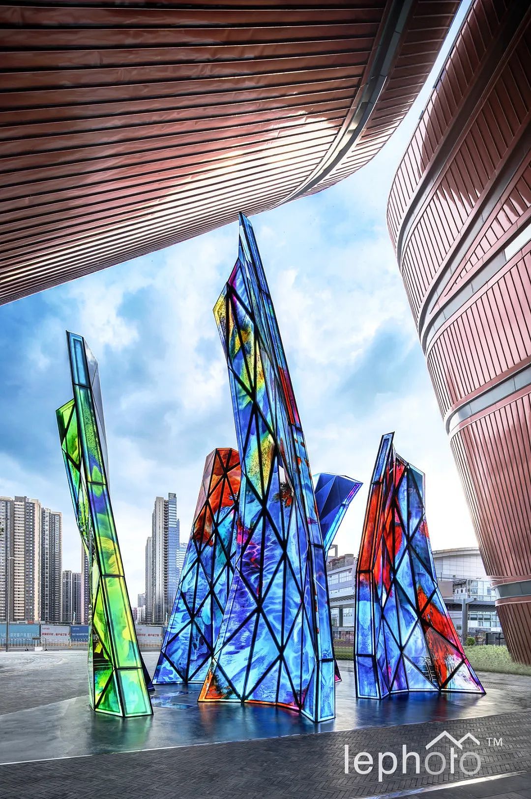 高880cm的《绽放》,每个雕塑单元都有主题,艺术家通过亲笔绘制五幅具有东方色彩的画面,然后通过电脑技术放大,再经过德国彼特玻璃工作室绘至建筑艺术玻璃上多次烧制完成艺术玻璃成品。