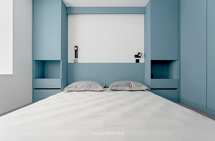 主卧室以灰蓝色为主要色调,再穿插白色的墙面,让整个卧室舒缓沉静。为了避免空间过于清冷,利用暖色壁灯烘托温馨的氛围。