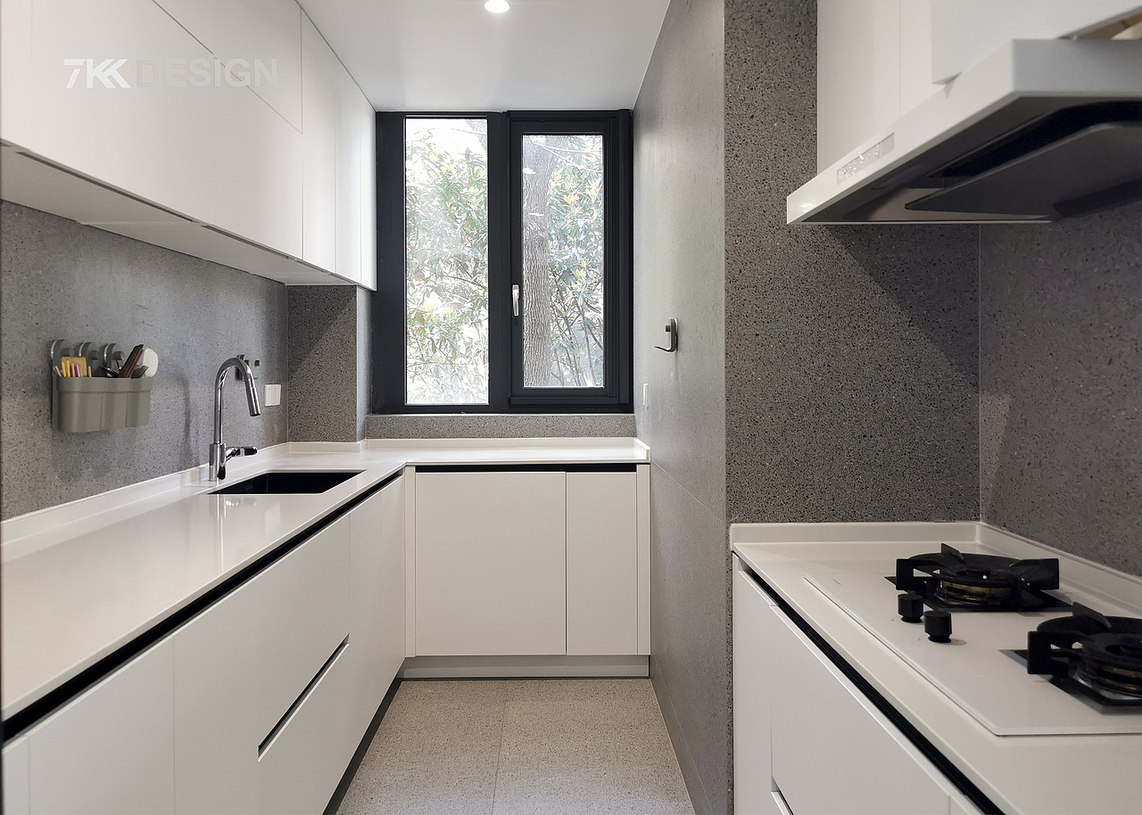 西厨进来便是中厨空间,白色橱柜搭配灰色墙砖,营造出干净清爽,层次分明的烹饪环境。