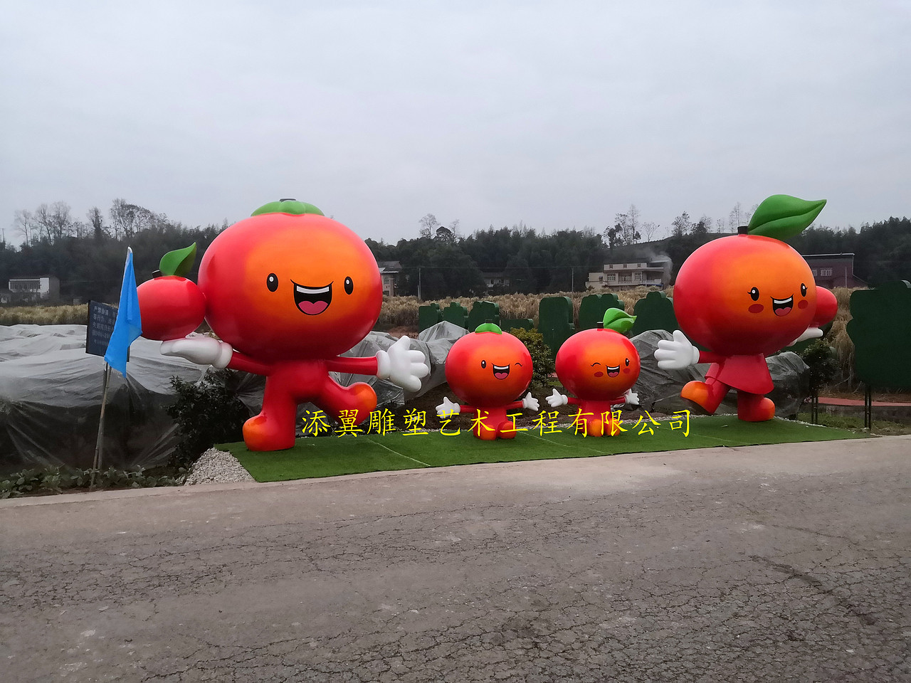 手捧橘色水果卡通雕塑摆件是果园招引旅客重要法宝之一