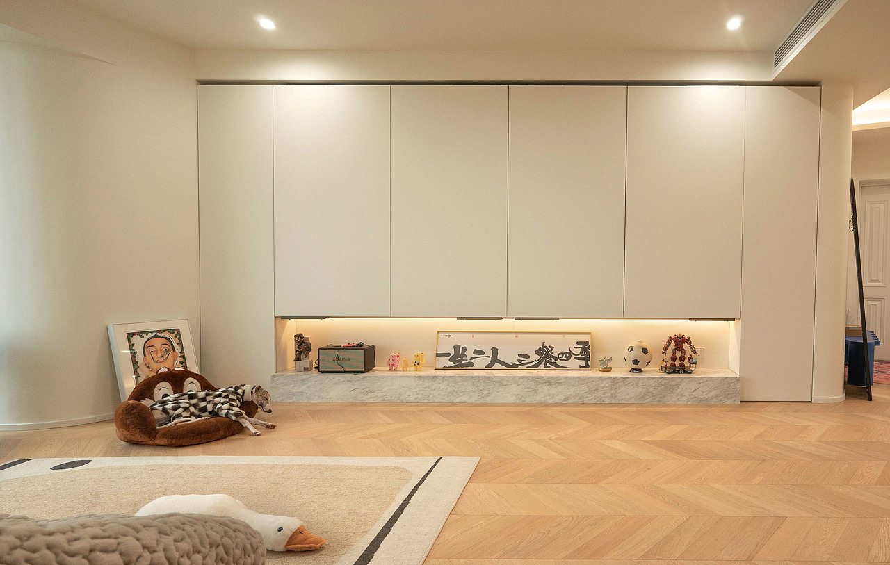 不能敲的墙体又利用了弧形做了过渡,同样与柜子相连,打开可以看电视和收纳,关起来就是纯平极简⻛。
柜子的巴士移门轨道也是设计师和厂家沟通了好久,一次次调整,才达到最终的完美效果。