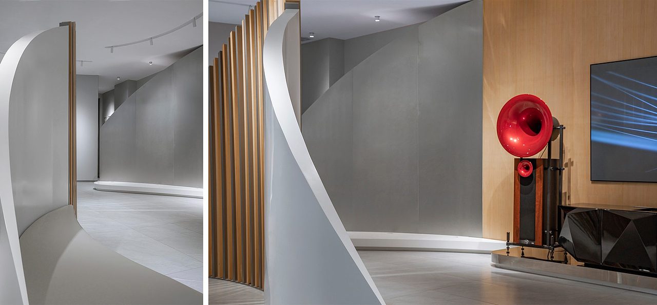 光线穿过木质格栅,落在曲面墙上,画出了灰色的影子,落在地上,则变成光束射向四方。大红色的播放器像一件沉默的雕塑,但漂浮在空间里的曼妙旋律又恰恰出自它。