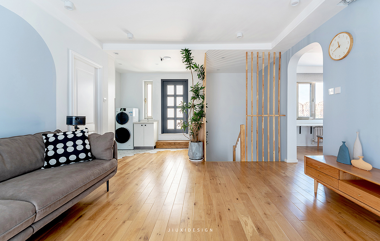 客厅也是整个二层的转换空间,连接着楼下和楼上以及阳台。楼梯处做通高的栏杆,也为安全性上提供保障。
沙发背景墙的弧形和书房的弧形门洞做呼应,整个烟蓝色和双雪白做背景。加入温润的木色,让整个空间柔和且静谧。<br>