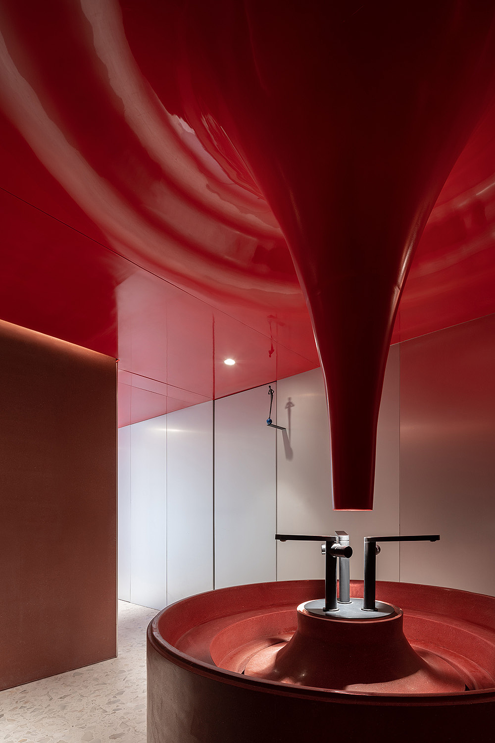 除了笔触,我们也试着以装置艺术观点处理色块形状,例如长廊尽头的洗手间,丹红覆盖,强烈色彩倏然收拢包覆,不对称立面及向下汇集的水滴轮廓艺术装置,相对于开放场域真空遥远的白,形体强化了红色的倾斜、流动意识。