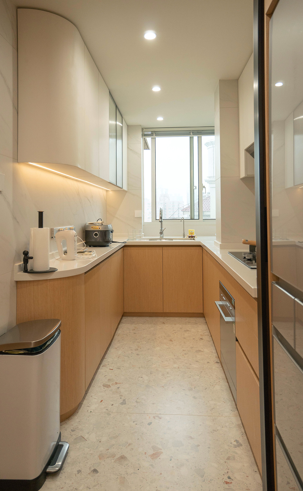 移门和冰箱隐藏于柜子中,灶台一侧的平面看起来干干净净。厨房不使用时移门就藏在柜子间,中厨与西厨联通,秒变开放式厨房。