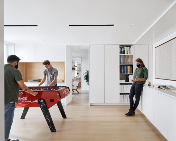 办公室装修方案:明亮的饰面、高品质的照明和空间策略掩盖了低矮的天花板