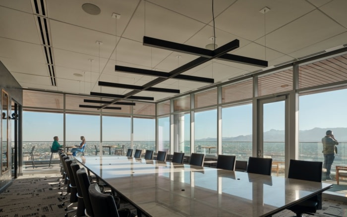 办公楼设计装修风格:中性、温暖的调色板与会议室附近的深色石板形成鲜明对比