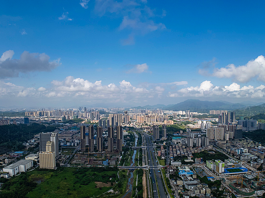 航拍蓝天白云下繁华的深圳坪山城区风貌