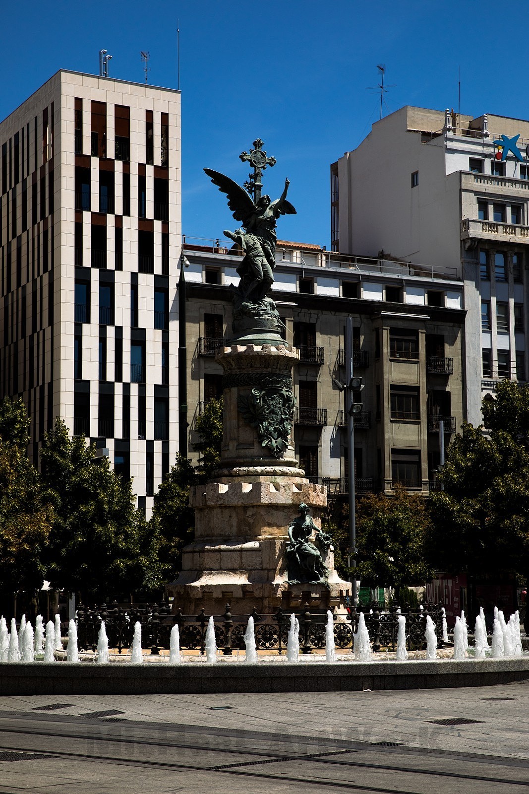 在整个萨拉戈萨的户外雕塑中,宗教与祖国烈士纪念碑(Monumento a los Mártires de la Religión y de la Patria)是我个人的最爱,虽然很传统的姿态,但是声色俱佳的天使简直是帅到不行。设计者,对,依旧是我们的里卡多-马格达莱纳老师,而雕塑由雕塑家奥古斯丁-奎罗尔(Agustin Querol)制作,纪念碑的目的是为纪念为这座城市付出一切甚至生命的人们,建于1904年10月23日。纪念碑下侧是一位带着树叶冠冕的女性代表着这座城市,它一首拿着胜利王冠,另一只手拿着羊皮纸和叶子,上面挂着代表阿拉贡首都历史的经文和悬挂的印章。而上侧是一位手指天堂,另一只手抱着一位倒下阿拉贡人的双翼天使形象。俗套,但是真的很带劲,有时候简单直白的表述更容易让人觉得热血沸腾~更何况这位天使真的超帅英气十足!用它来结束萨拉戈萨的这段旅途,我想非常的合适。
<br><br>