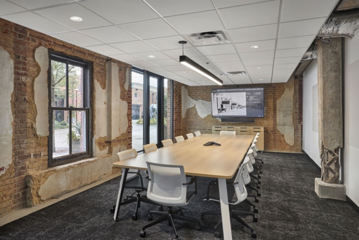 原始砖和混凝土的自然元素在办公楼空间中得到了诚实的展示