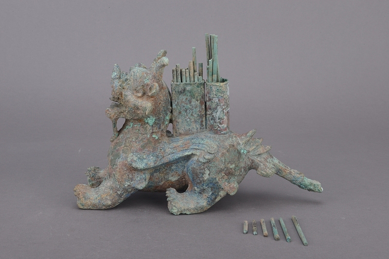 以楚文化博物馆铜鎏金兽形承托器为灵感源泉,设计出一款 Q 版铜鎏金瑞兽形象。将兽首轮廓线条柔化为圆润弧线,以夸张放大的萌态兽眼、蓬松卷曲的绒毛质感取代古朴造型,同时保留鎏金纹路的古典韵律。