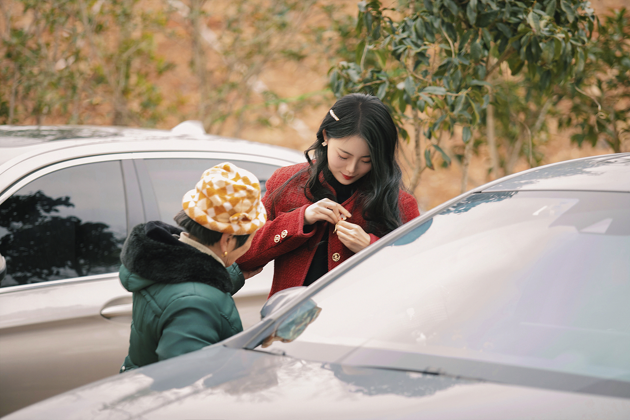 奶奶慈祥的看着孙媳妇整理饰品