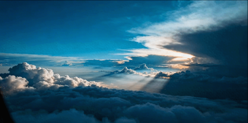 飞行器继续在云层中穿行,下方的白色云层持续翻滚流动,光线从云层缝隙中不断透射下来,形成动态的光束效果,镜头保持稳定的飞行视角,展现穿越大气层的速度感和空间感,整体保持冷蓝色调的科幻氛围。
