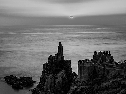 岛礁上观看日出的游人